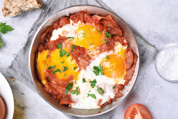 Fried eggs with tomato sauce and bacon