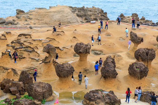 Tourists at the Yeliu (Yehliu) Geopark in Wanli District, New Taipei, Taiwan at a rainy, windy and overcast day