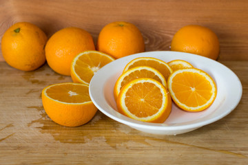 Oranges on a table and on a white plate