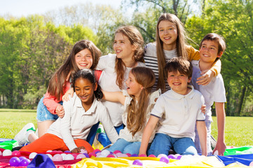 Happy kids having fun sitting on grass in the park