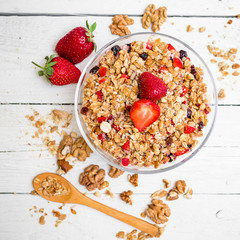 Oatmeal porridge with blueberry, strawberries and muesli on wooden background. Flat lay. Top view. Natural tasty breakfast 
