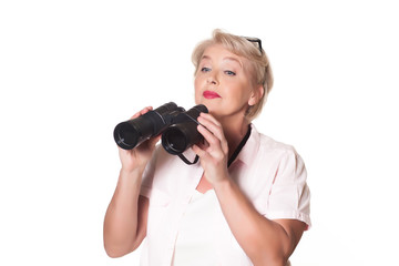 Beautiful elderly woman looking through binoculars over a white background