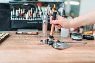 Make up artist hand with brush prepares cosmetics