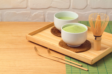 Matcha green organic tea cup and powder on wooden table