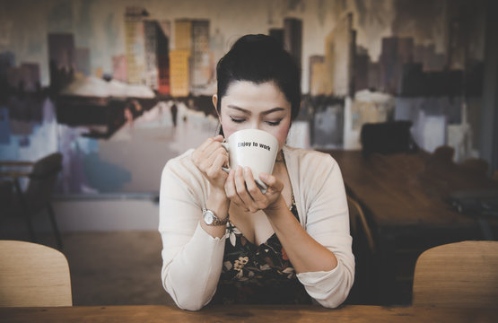 Asian woman drinking coffee in vintage color tone