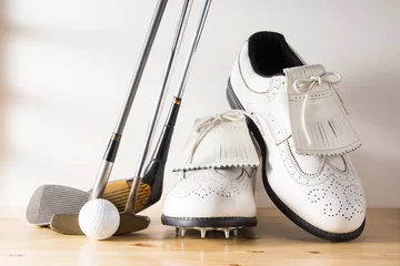 Papier Peint photo Golf used white leather shoes, golf club and ball on pine wood floor against rustic wall