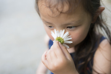 白い花の香りを嗅ぐ女の子