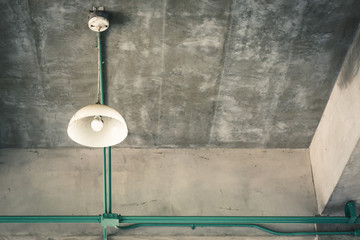 old white lamp at the concrete ceiling and conduit at structure, dramatic vintage color tone