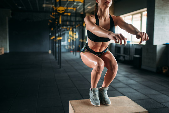 Woman doing box jump exercise in fitness club