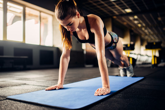 Female athlete doing push-up exercises in gym