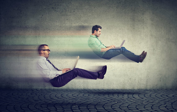 Fast internet concept. Two levitating business men on road using laptop