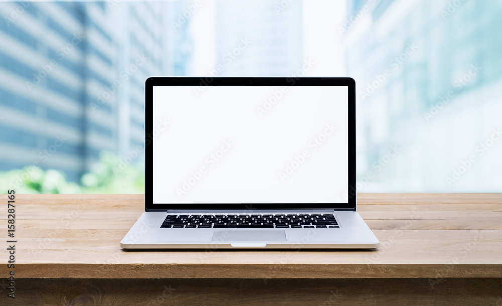 Wall mural modern computer,laptop with blank screen on wood table with office window view background
