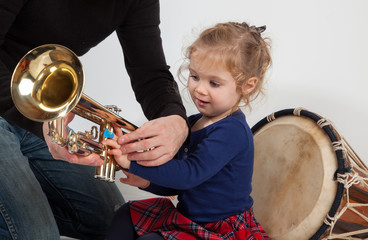 Kleines aufmerksames Mädchen mit Trompete