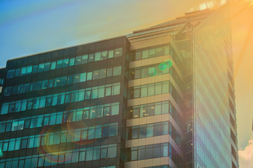 The building is a business center glass with green and blue windows, sunlight and glare