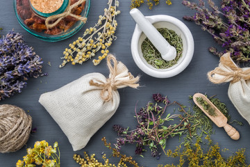 Medicinal herbs, mortar of healing herbs, sachet and bottle of healthy drugs on wooden table. Herbal medicine. Top view, flat lay. - obrazy, fototapety, plakaty