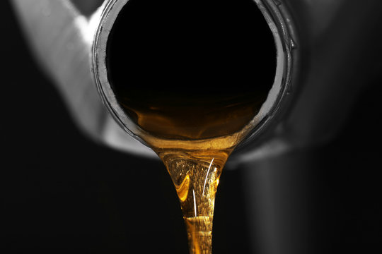 Engine oil pouring from canister, closeup