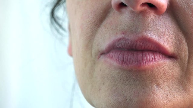 close up of old woman moistening her lips with tongue
