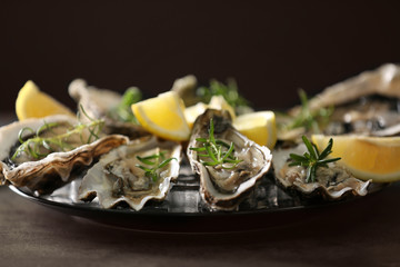 Tasty fresh oysters with sliced juicy lemon on plate. Aphrodisiac food for increasing sexual desire