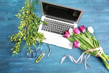Fotobehang Bloemenwinkel Beautiful flowers and laptop on florist's workplace