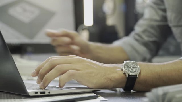Designer working on laptop computer, cropped