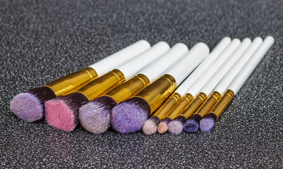 Set of white make up brushes isolated on black background