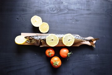 Smoked fish with lemon, on wooden board, Mackerel