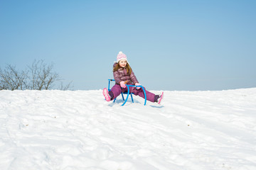 Fototapeta na wymiar Little girl on a sledge