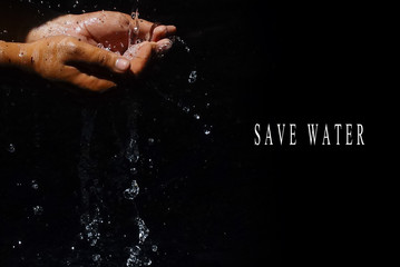 Fototapeta na wymiar Human Hand Capturing Flowing Water With SAVE WATER Words Over Black Backgrounds