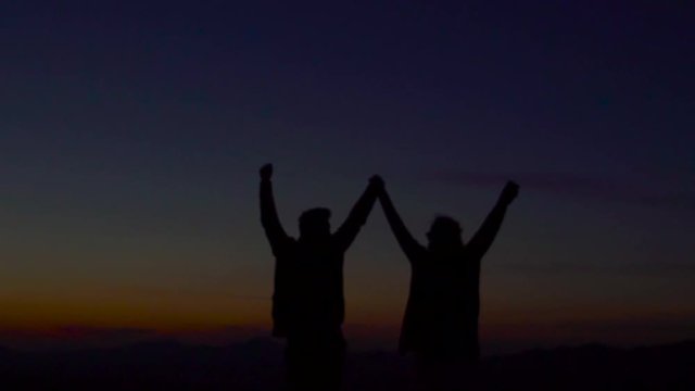 Silhouette of couple on the background of mountains.
