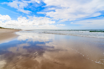 Wet sand and clouds reflections on List beach, Sylt island, North Sea, Germany