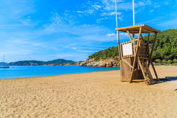 Lifeguard tower and sandy beach in Cala San Vicente bay, Ibiza island, Spain