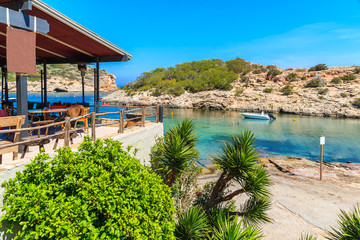 View of bay and small restaurant in Cala Portinatx, Ibiza island, Spain