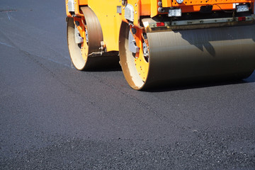 close up on compactor roller paving the asphalt road