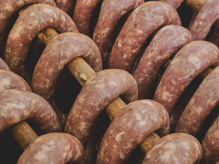 A group of smoked sausages hung on a stick over a smoke. This is a natural tasty product without...