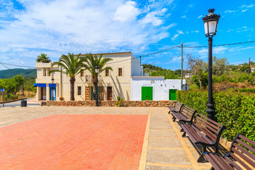 Square with colourful houses and palm trees in Sant Carles de Peralta village, Ibiza island, Spain © pkazmierczak