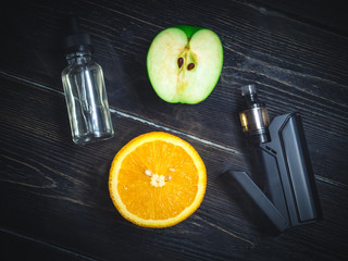black vaporizer in the smoke with sliced orange and apple