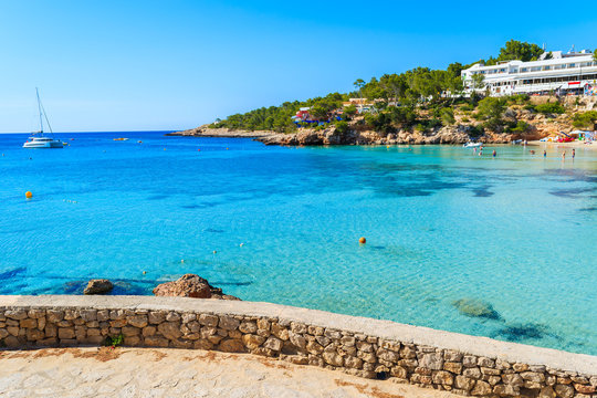 View of azure sea water in Cala Portinatx bay from coastal promenade, Ibiza island, Spain