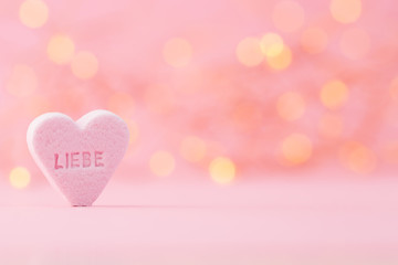 Pastel colored candy hearts in a bokeh background.