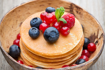 Stack of pancakes with blueberry and fresh berry.