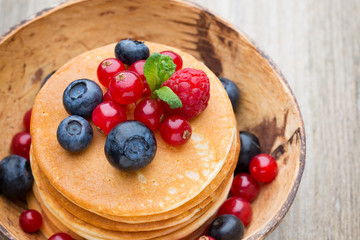 Stack of pancakes with blueberry and fresh berry.