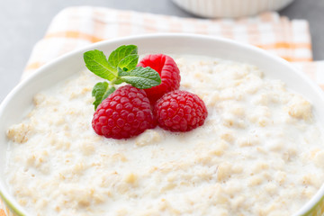 Oatmeal porridge in bowl with berries raspberries and blackberries.