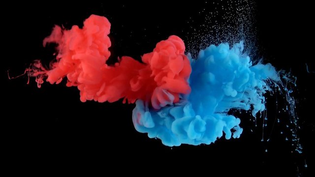 Real shot color paint drops in water in slow motion. Ink swirling underwater. Cloud of ink collision isolated on black background with alpha. Colorful abstract smoke explosion animation. Close up view