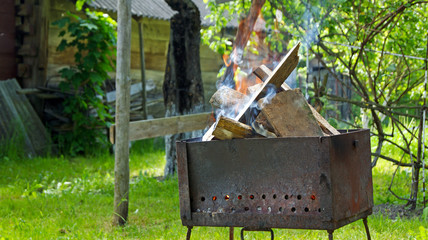 Potatoes and fried meat on the grill in the open air