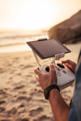 Man flying drone from a beach