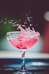 pink drink splashing in glass