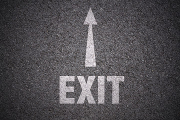 white arrow and exit lettering on asphalt background