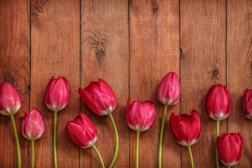 brown wooden background with red tulips