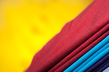 Stack of different cotton t-shirts on wooden table