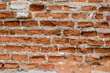 Red brick wall texture shattered by time. Grunge background