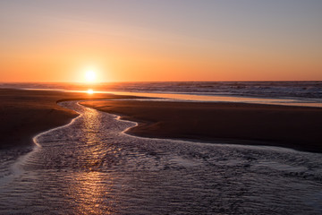 ocean water leading toward sunset at the beach